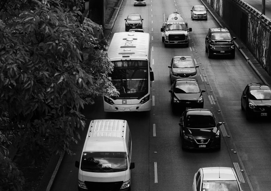 Black-and-white overhead view of traffic moving through an urban road